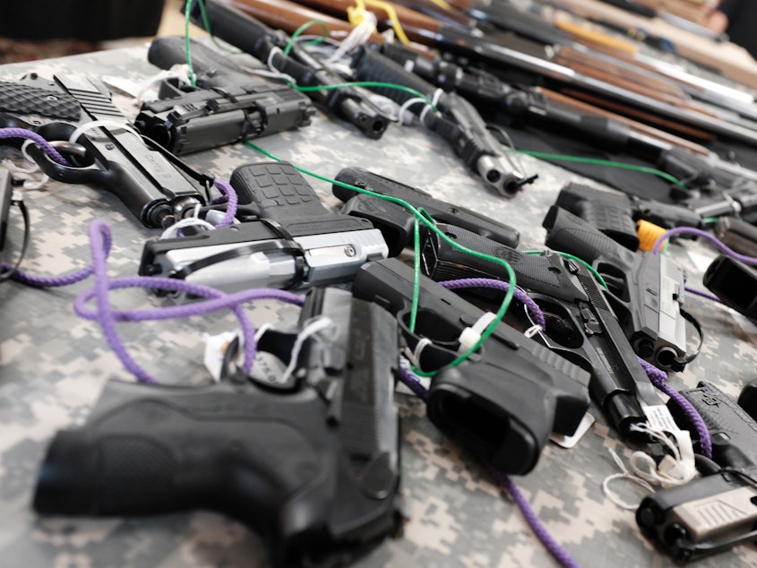 caption: Guns for sale at a gun show in Naples, Fla.