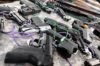 caption: Guns for sale at a gun show in Naples, Fla.