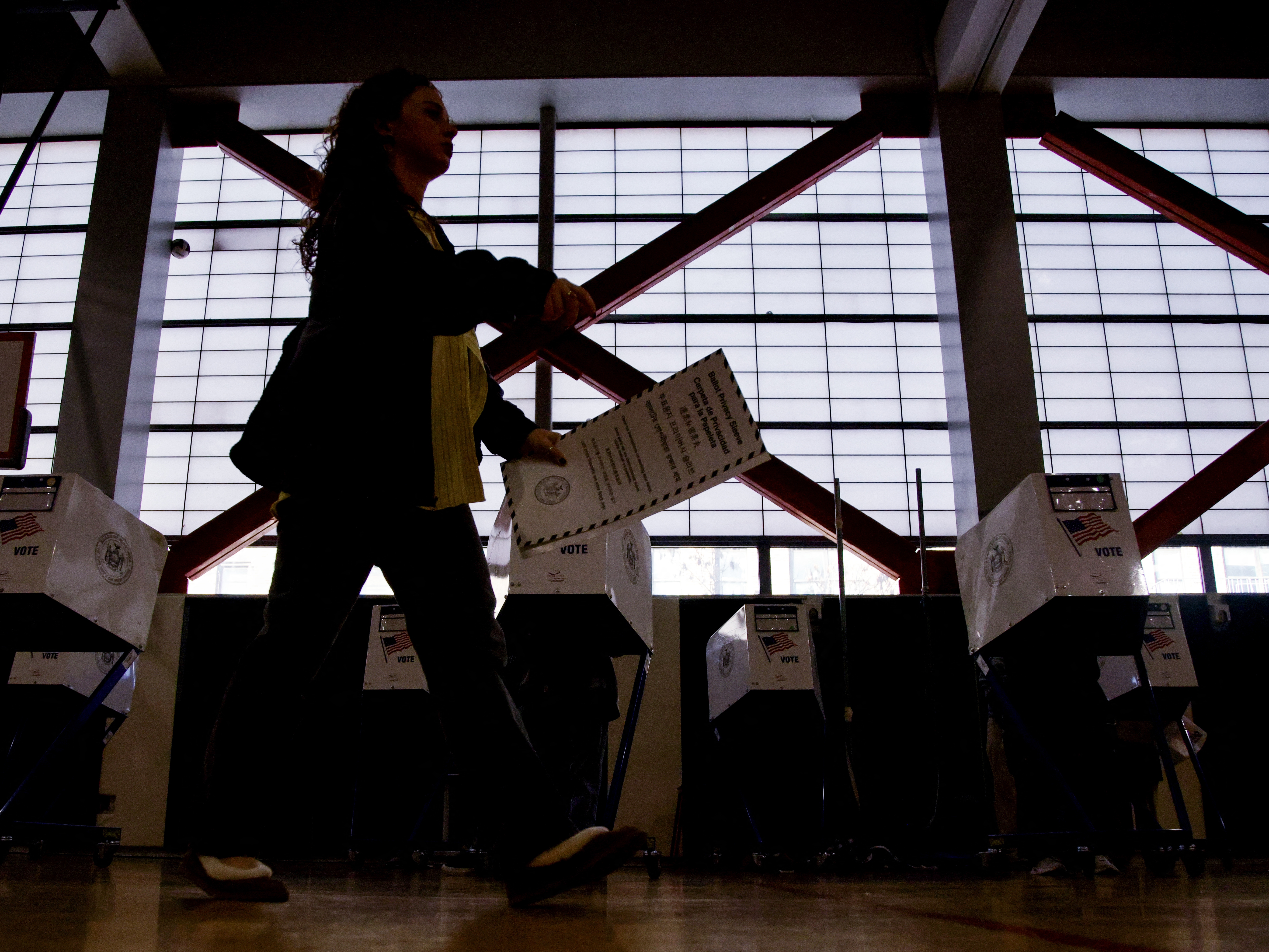 caption: People vote at a polling location in Queens during New York City's mayoral election on Nov. 4, 2025.