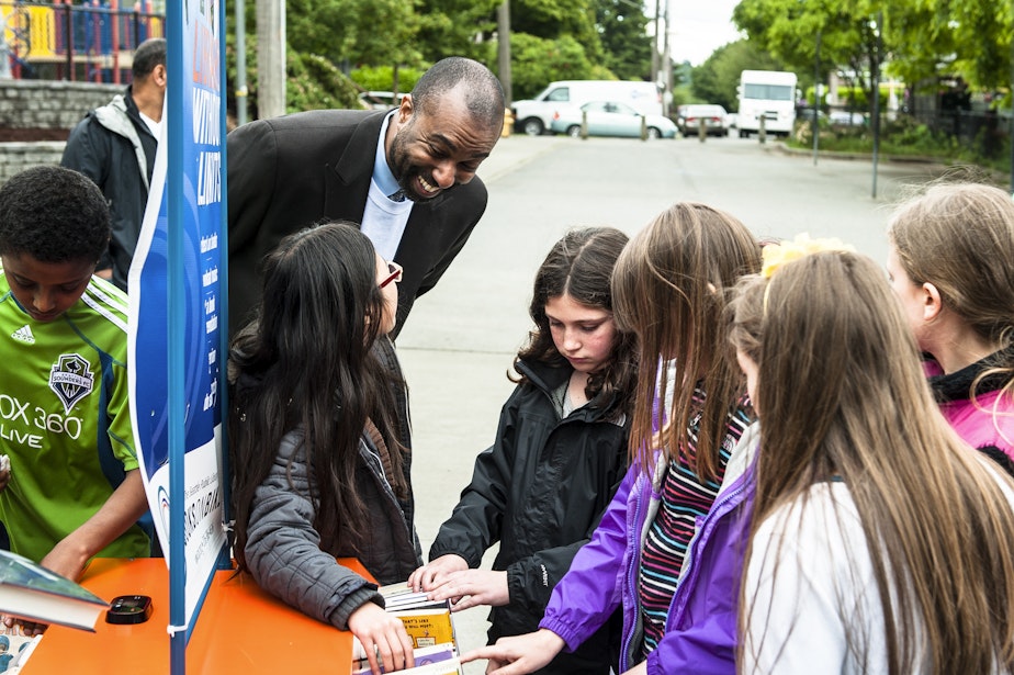 caption: Marcellus Turner, the city's chief librarian, greets young library customers at a Seattle Public Library event on May 21, 2013. Turner announced he would leave for a new opportunity in April 2021.