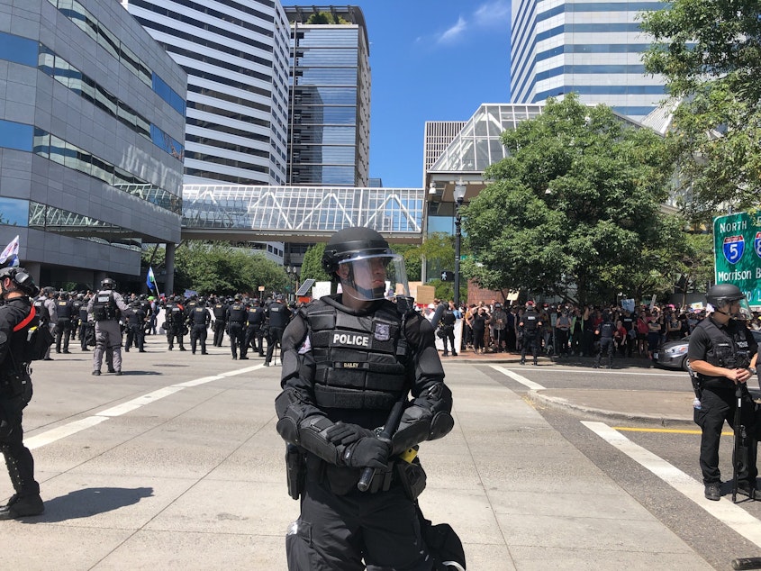caption: A Portland Police Bureau officer controlling the crowd at a protest on Saturday, August 4th, 2018.