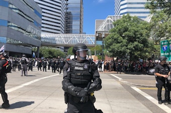 caption: A Portland Police Bureau officer controlling the crowd at a protest on Saturday, August 4th, 2018.