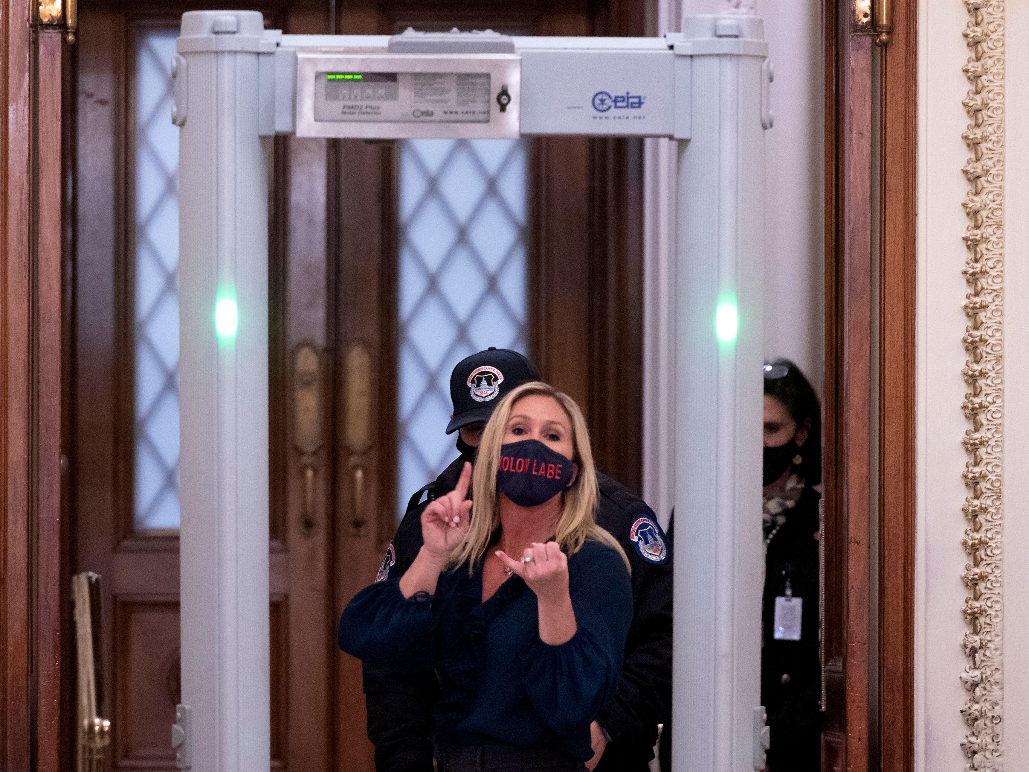 caption: Republican Rep. Marjorie Taylor Greene of Georgia shouts at journalists as she goes through security outside the House Chamber at Capitol Hill.