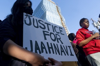 caption: A protester holds a sign calling for justice as people protest Thursday, Sept. 14, 2023, in Seattle after body camera footage was released of a Seattle police officer joking about the death of Jaahnavi Kandula, a 23-year-old woman hit and killed in January by officer Kevin Dave in a police cruiser. 