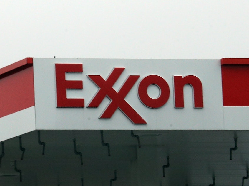 caption: An Exxon station in Hicksville, N.Y., is shown on March 20, 2020. ExxonMobil announced up to $20 billion in write-downs of natural gas assets, the biggest such action ever by the company.