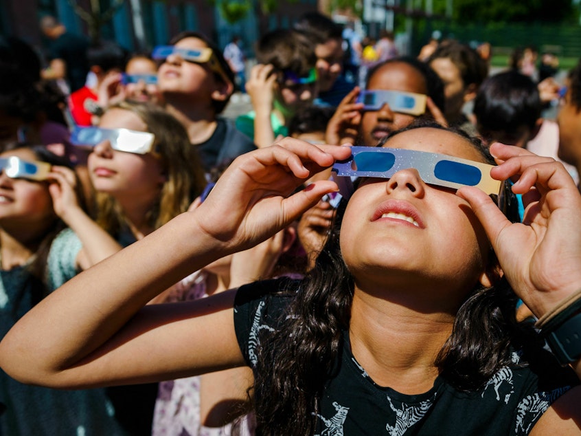 caption: Pupils, wearing protective glasses, look at the partial solar eclipse in Schiedam, the Netherlands, on June 10, 2021.