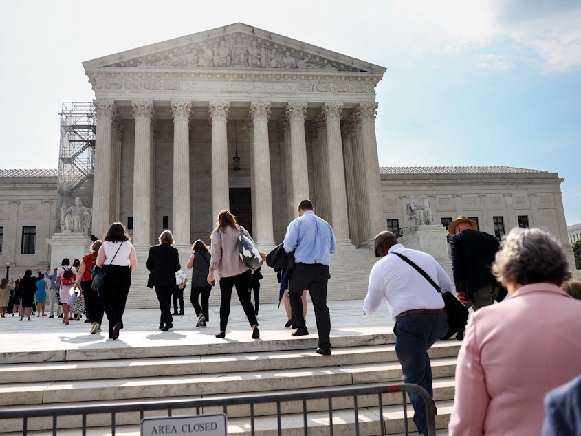 caption: People walk into the U.S. Supreme Court in Washington, D.C., on Tuesday, the day that the court's majority rejected the once-fringe idea that state legislatures' power over congressional elections cannot be checked or balanced by state constitutions or state courts.