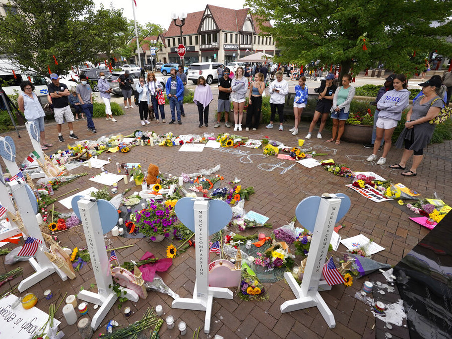 caption: Area residents visit a memorial Wednesday to the seven people who lost their lives in the Highland Park, Ill., Fourth of July mass shooting.