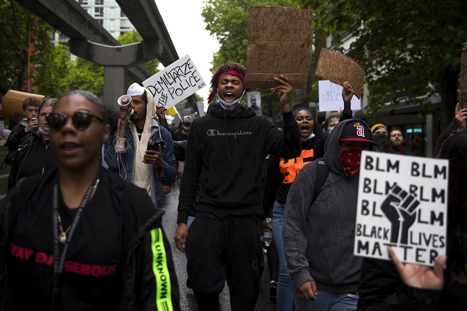 caption: Da'miracle Muse, center, leads a chant, -- 'we do this for our children. We do this for our children's children,' while marching in protest of the police killing of George Floyd on Saturday, May 30, 2020, in Seattle. 