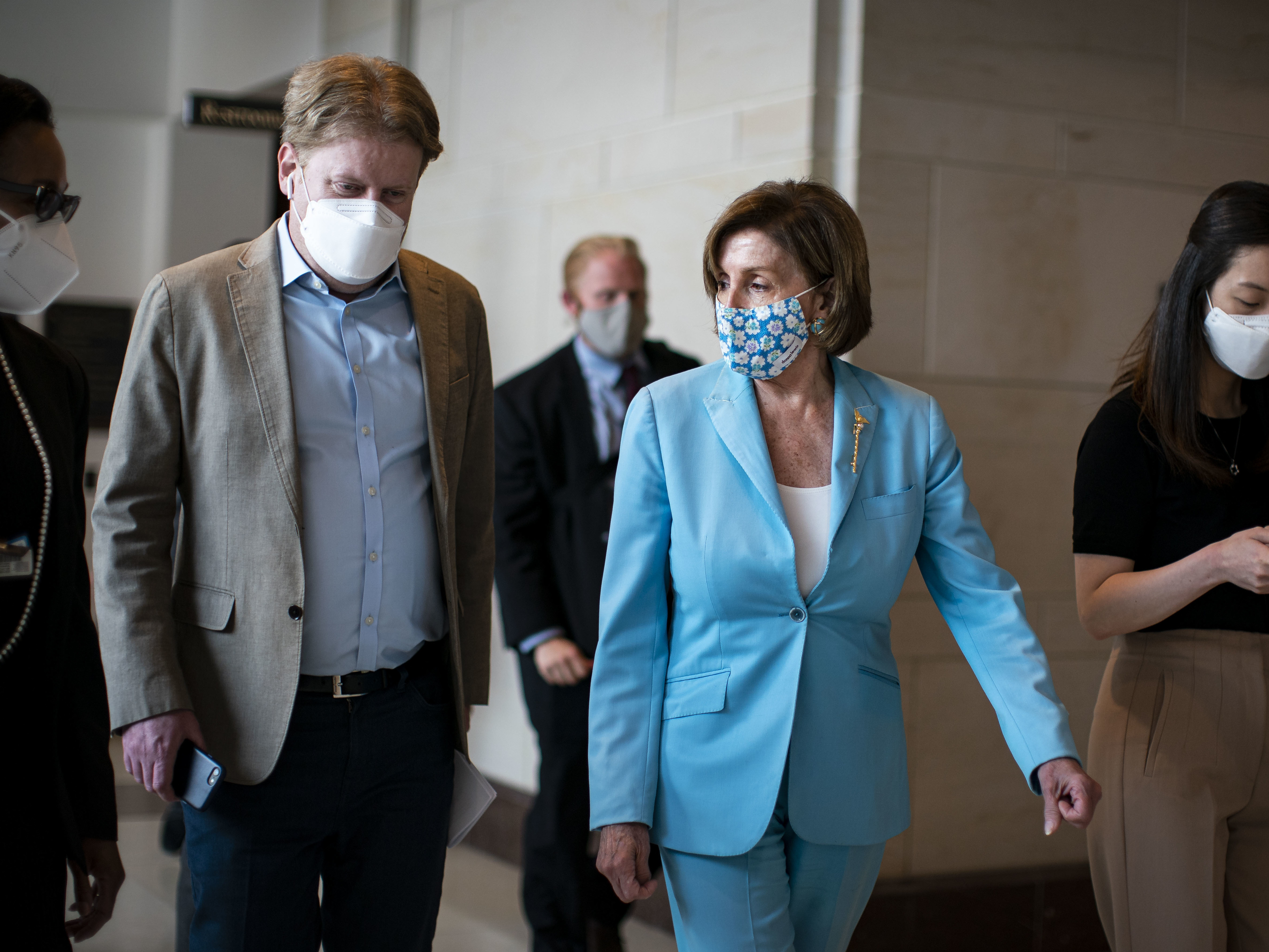 caption: House Speaker Nancy Pelosi, D-Calif., wears a mask as she departs a news conference at the U.S. Capitol on Wednesday.