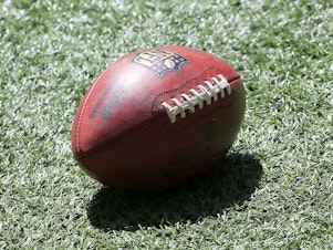 caption: A football lies on the turf prior to the NFL Week 1 game between the Atlanta Falcons and the Seattle Seahawks on September 13, 2020.