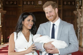 caption: Britain's Prince Harry and Meghan, Duke and Duchess of Sussex, hold their newborn son in St. George's Hall at Windsor Castle on Wednesday. Archie Harrison Mountbatten-Windsor was born Monday morning.