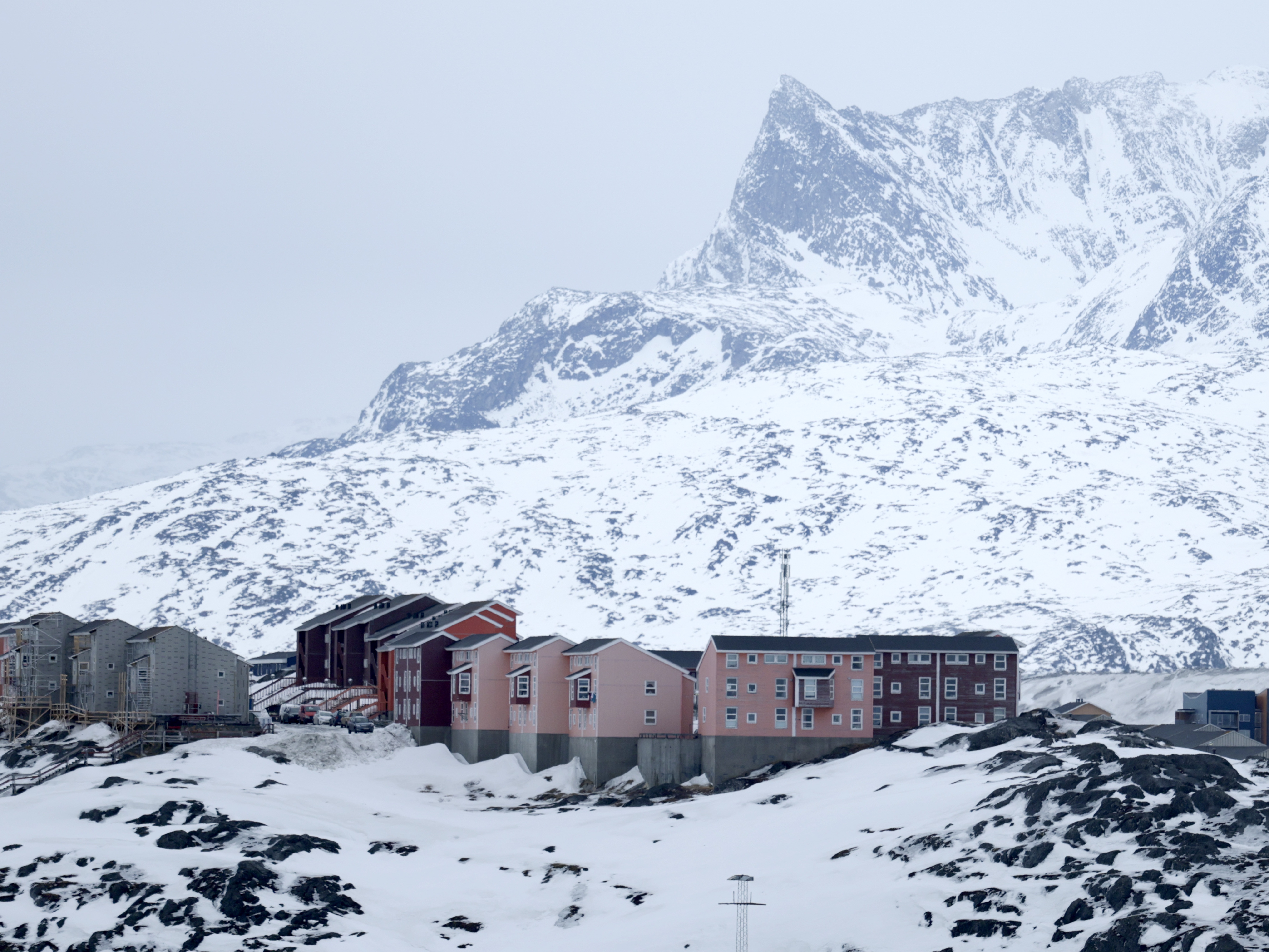caption: Homes built into the rugged landscape in Nuuk, Greenland, are seen on March 12. The self-ruling Danish territory has been thrust into the geopolitical spotlight as President Trump has vowed to acquire it.
