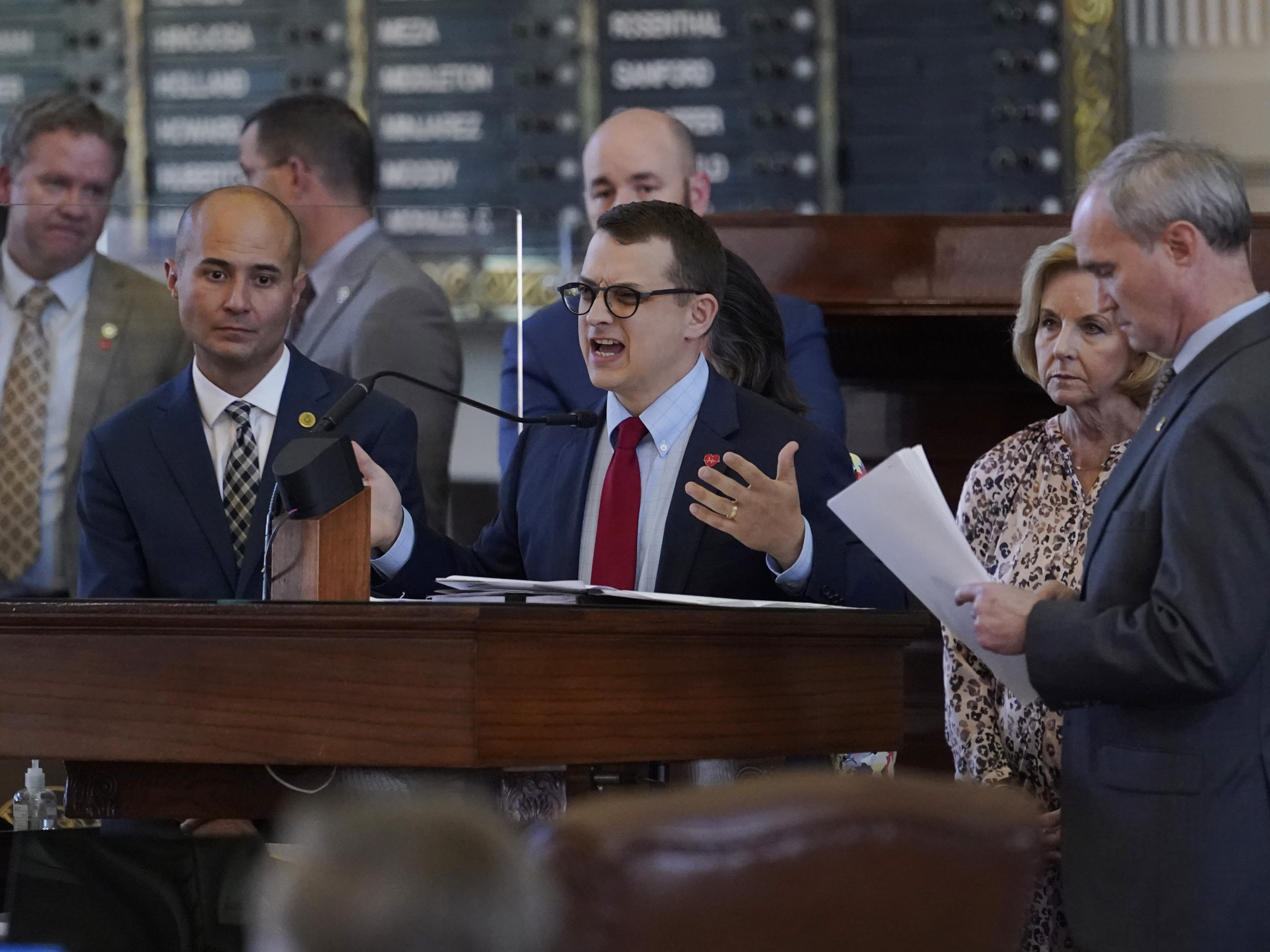 caption: Republican state Rep. Briscoe Cain, center, stands with co-sponsors as he answers questions and speaks in favor of an election bill, in the House Chamber at the Capitol in Austin, Texas, on Thursday.