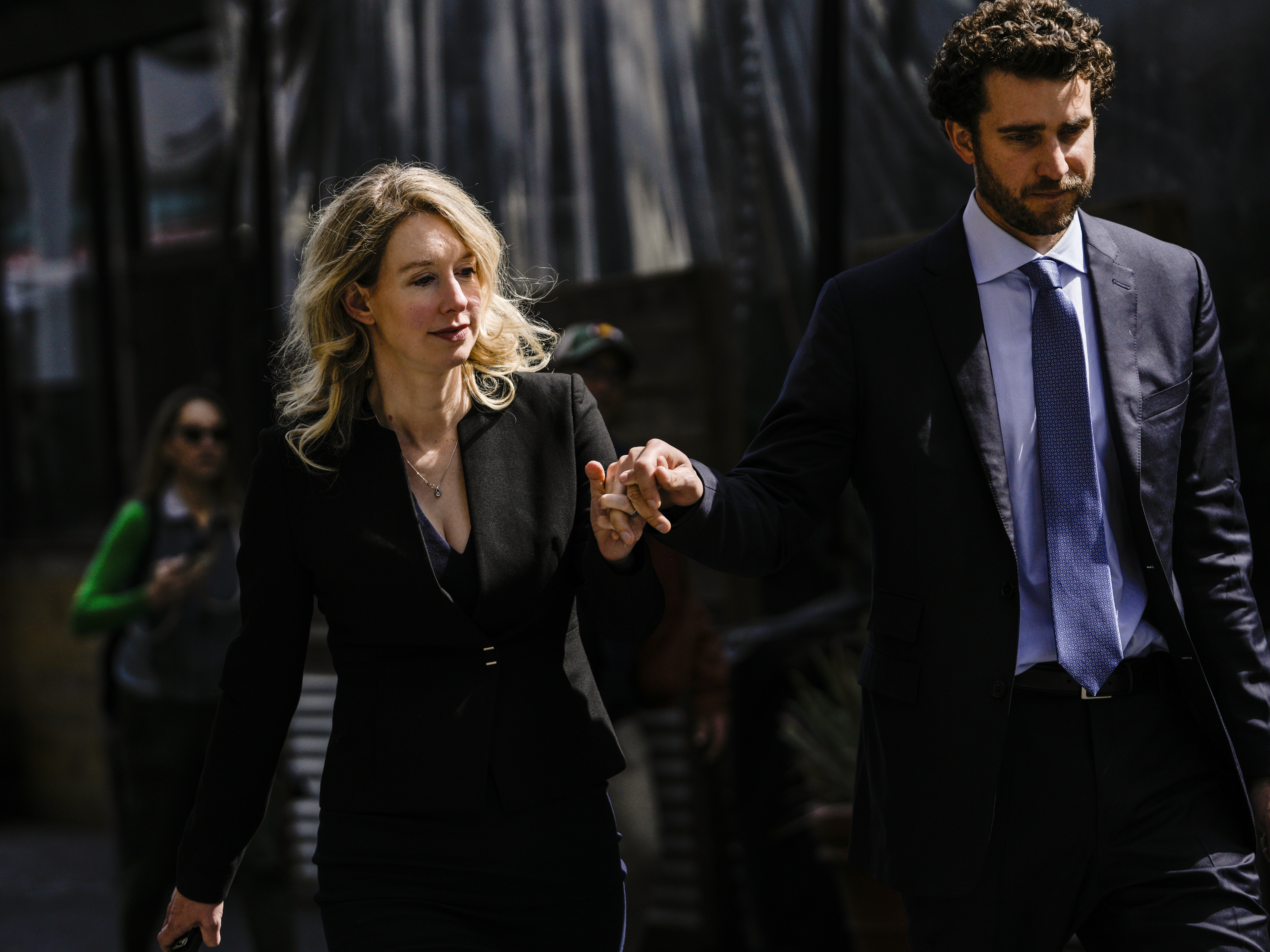caption: Former Theranos CEO Elizabeth Holmes and her partner, Billy Evans, following a hearing at the Robert E. Peckham U.S. Courthouse on March 17, 2023 in San Jose, California. Evans has raised millions of dollars for a new health tech startup that Holmes is advising him on.