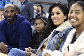 caption: Basketball great Kobe Bryant (from left), daughter Gianna, wife Vanessa and daughter Natalia are seen before an NCAA college women's basketball game in 2017 in Los Angeles. Vanessa Bryant says Nike is making, without her consent, a shoe she designed in honor of her late daughter, Gianna.