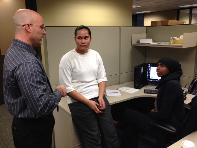 caption: Washington Federal technical support supervisor Pat Harding trains Year Up interns Freda Crichton and Fadumo Ali to remotely log in to bank branch computers.