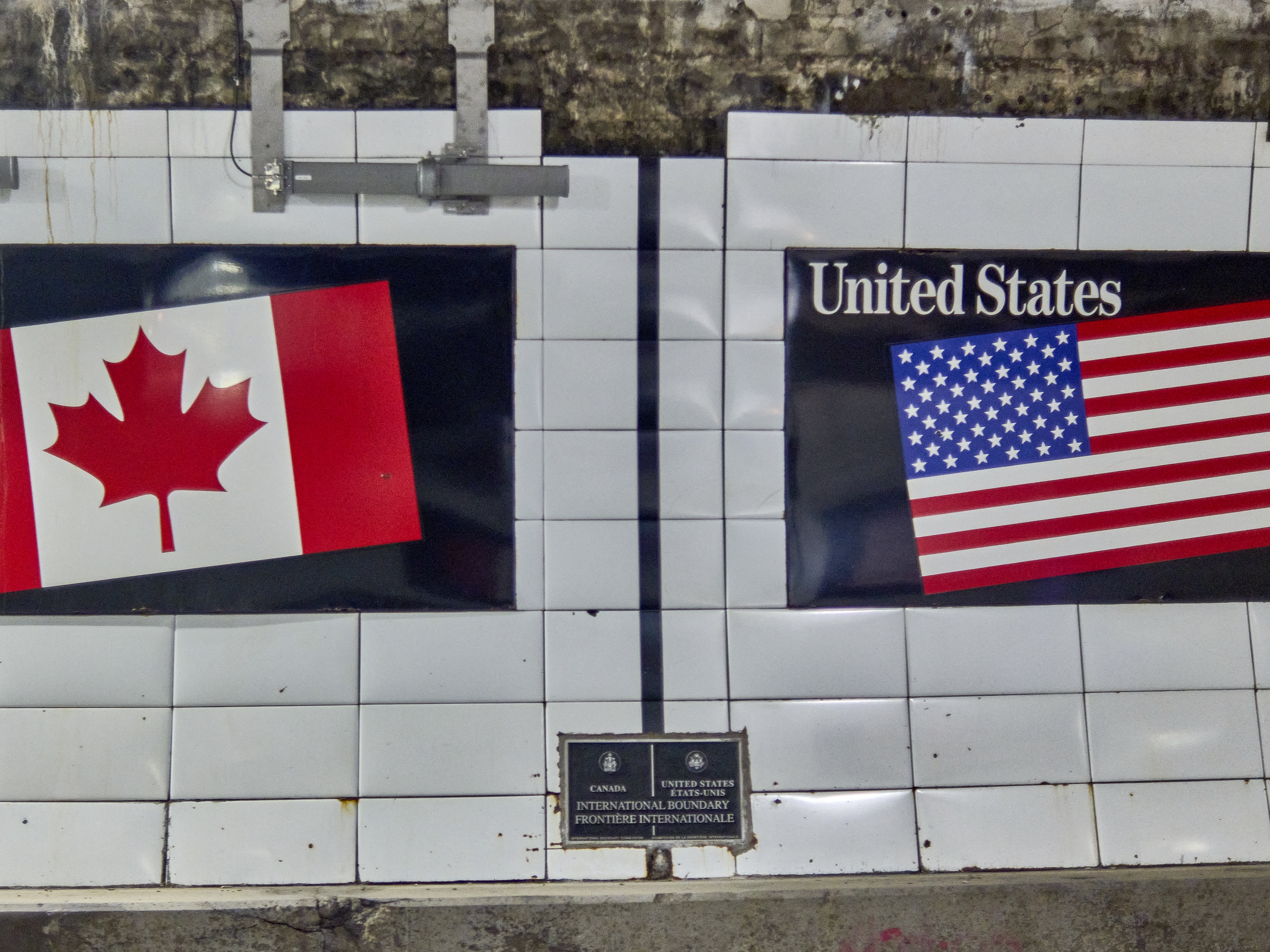 caption: The demarcation line marking the border between Canada and the United States is seen in the Detroit-Windsor Tunnel in May.