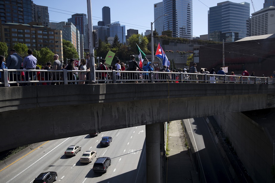 caption: A crowd marches on Pine Street toward the U.S. Courthouse on Wednesday, May 1, 2019, during the 20th annual May Day march in Seattle.