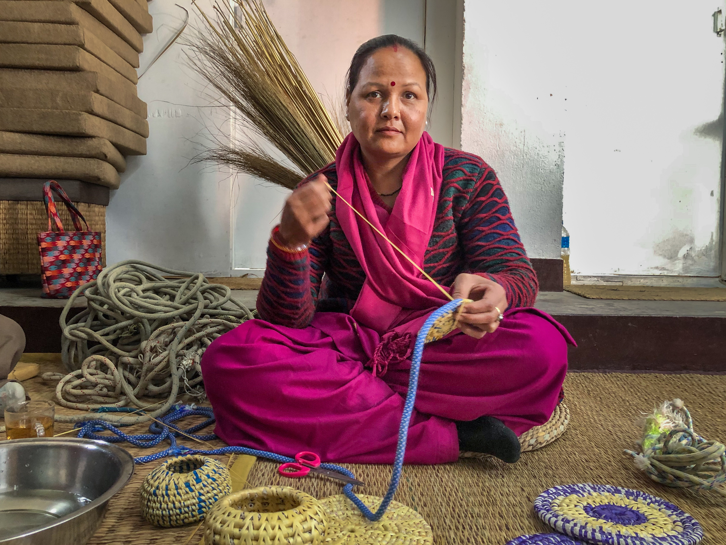 caption: Sunita Kumari Chaudhary weaves a dinner table mat with ropes once used by climbers in the Himalayas. She and her fellow craftswomen are part of a small start-up project in Kathmandu Valley, Nepal, to repurpose Everest trash.
