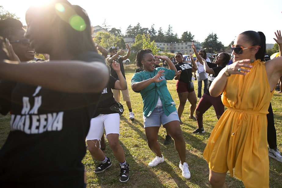caption: Shakiah Danielson, center, dances with friends and family of Charleena Lyles during the one year remembrance, reflection and healing event on the anniversary of her death on Monday, June 18, 2018, at Magnuson Park in Seattle.