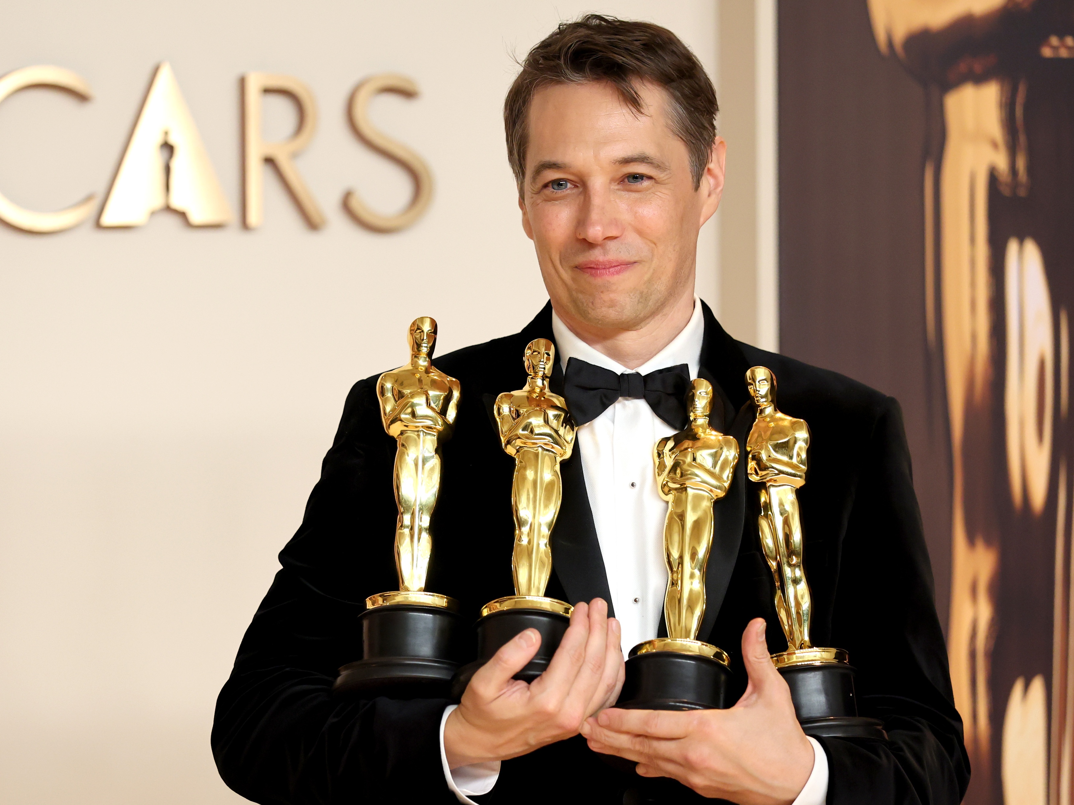 caption: Sean Baker, who won Oscars for directing, film editing, original screenplay and best picture for <em>Anora</em>, poses in the press room during the 97th Academy Awards.