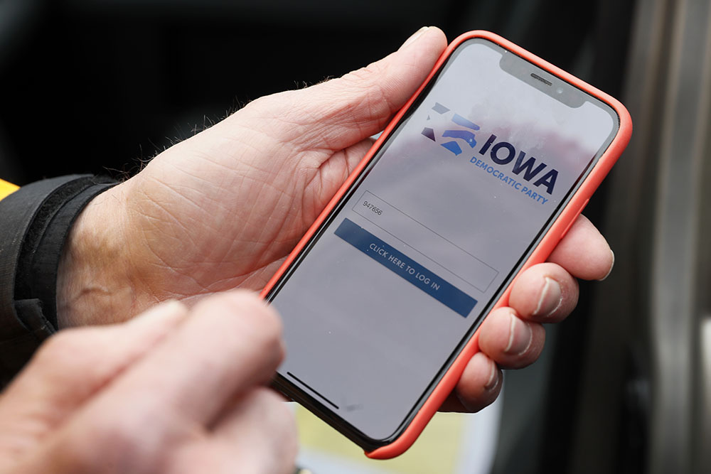 caption: Precinct captain Carl Voss holds his iPhone that shows the Iowa Democratic Party's caucus reporting app Tuesday, Feb. 4, 2020, in Des Moines, Iowa. (Charlie Neibergall/AP Photo)