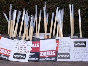 caption: Placards are gathered together at the close of a picket by members of The Writers Guild of America outside Walt Disney Studios, Tuesday, May 2, 2023, in Burbank, Calif.