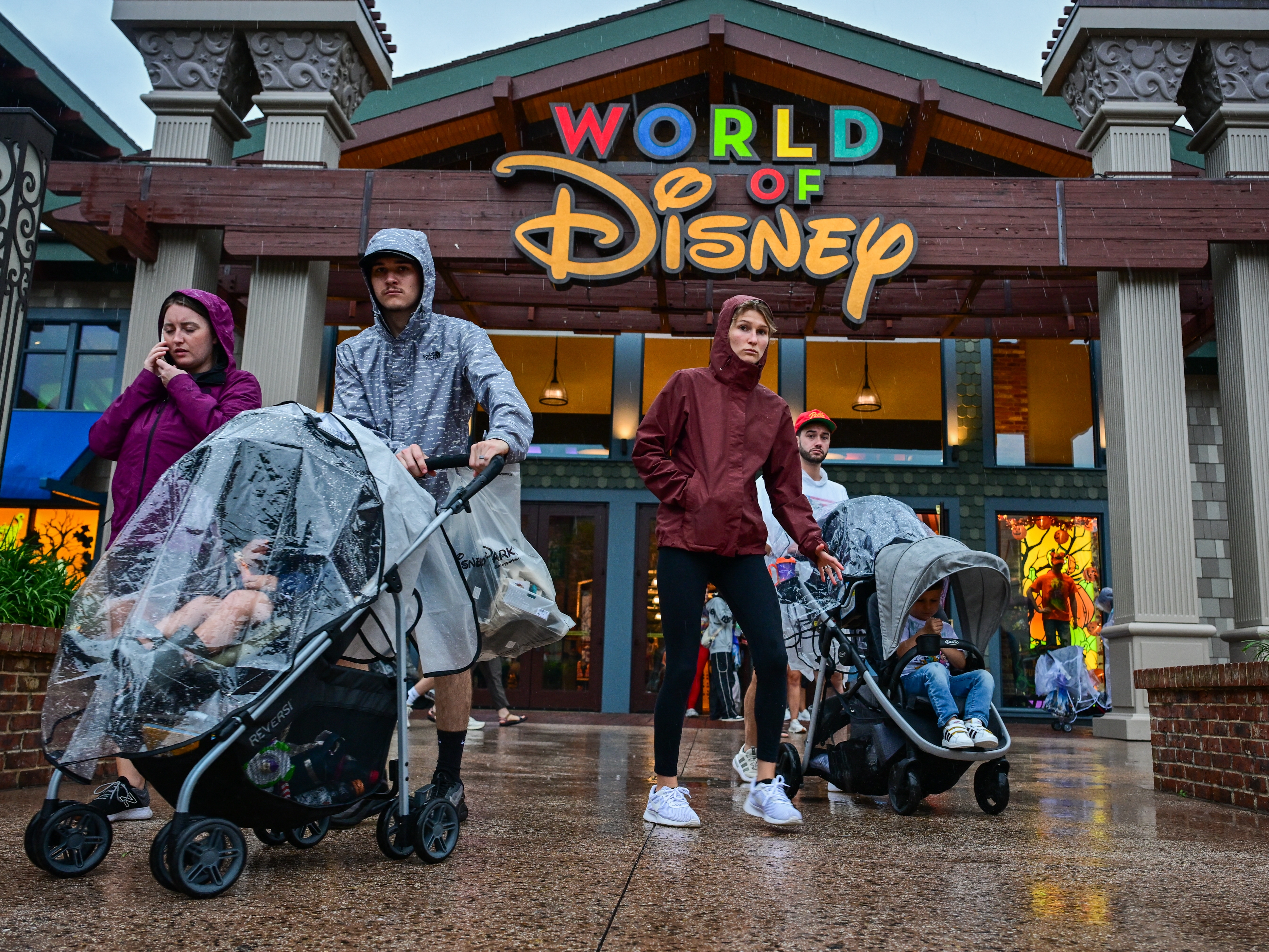 caption: Visitors walk through the Disney Springs shopping center in Orlando ahead of Hurricane Milton's landfall in Florida on Oct. 9, 2024.