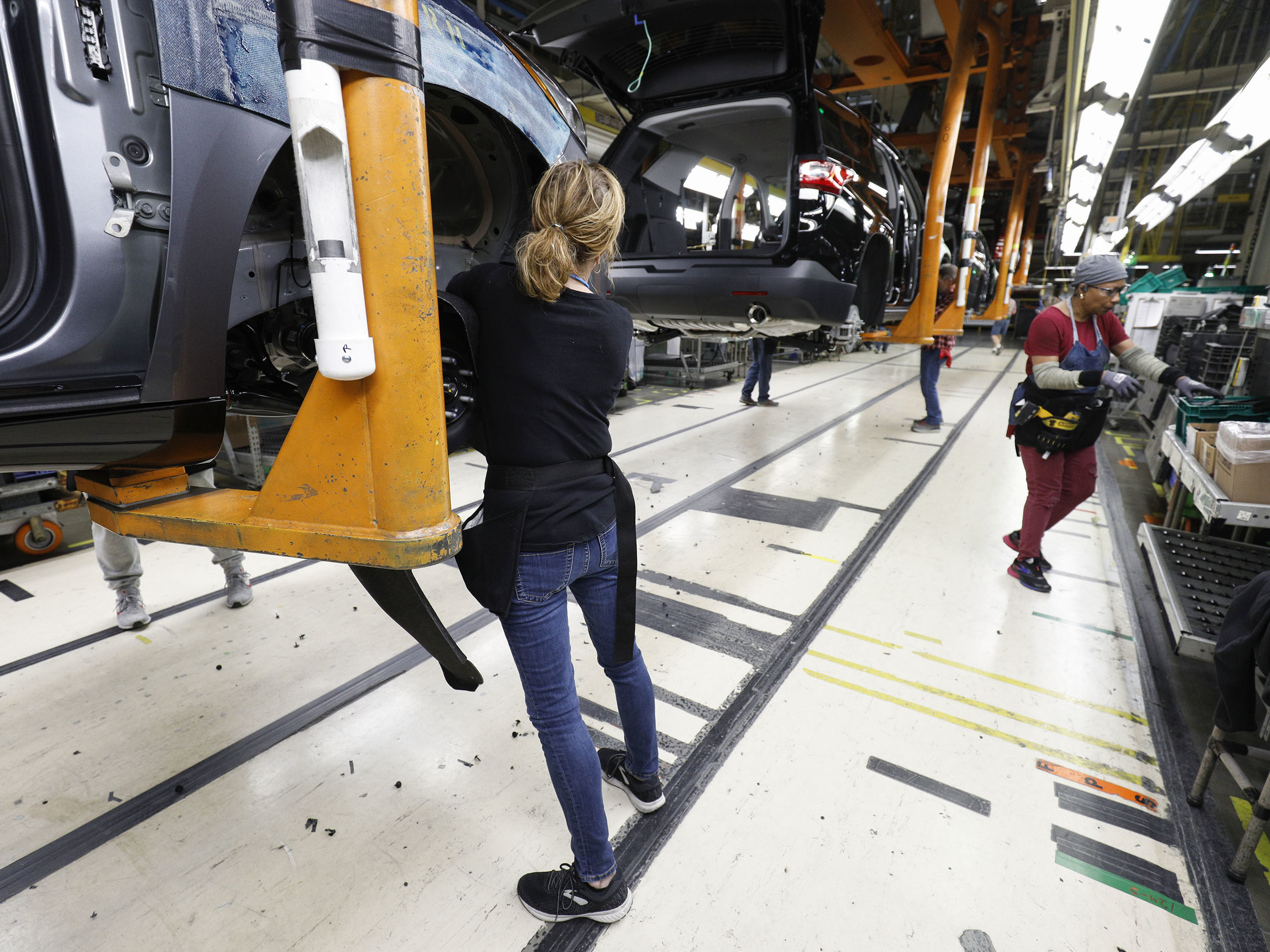 caption: Vehicles go through the assembly line at a General Motors assembly plant in Lansing, Mich., on Feb. 21. GM is assessing the feasibility of converting its plants to make medical equipment.
