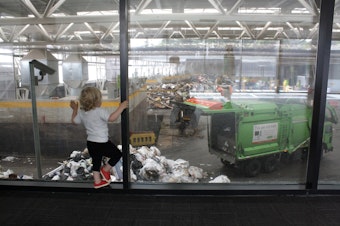 caption: A toddler watches the garbage trucks at Wallingford's rebuilt transfer station
