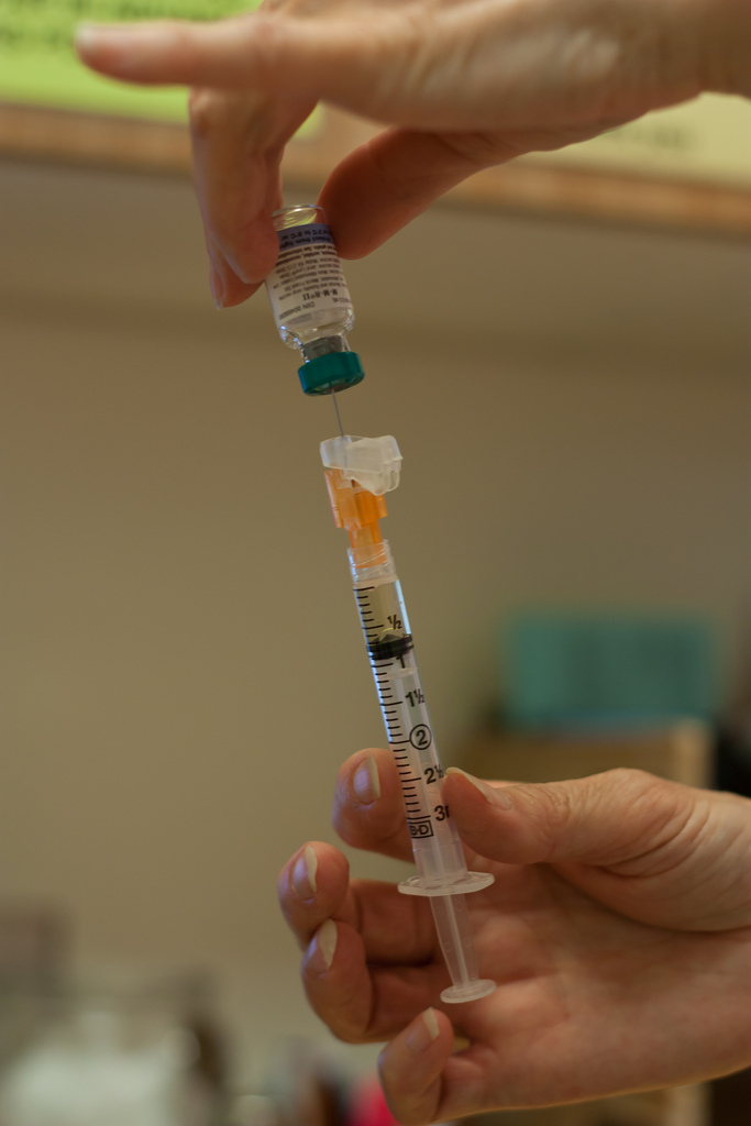caption: A physician prepares to give the mumps vaccine