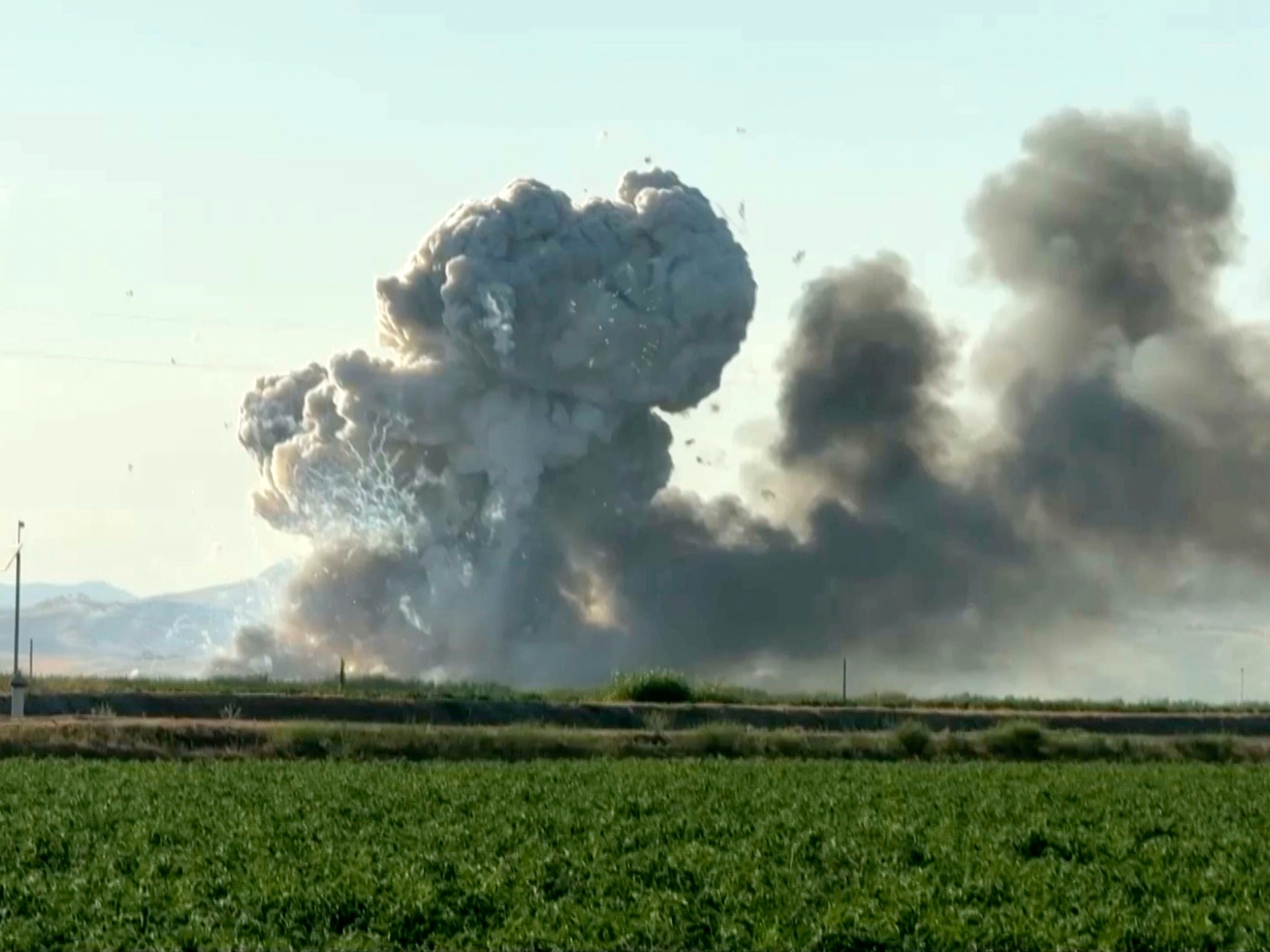 caption: In this image taken from video, smoke and flames rise from a fireworks warehouse explosion on  July 1 in Esparto, Calif.