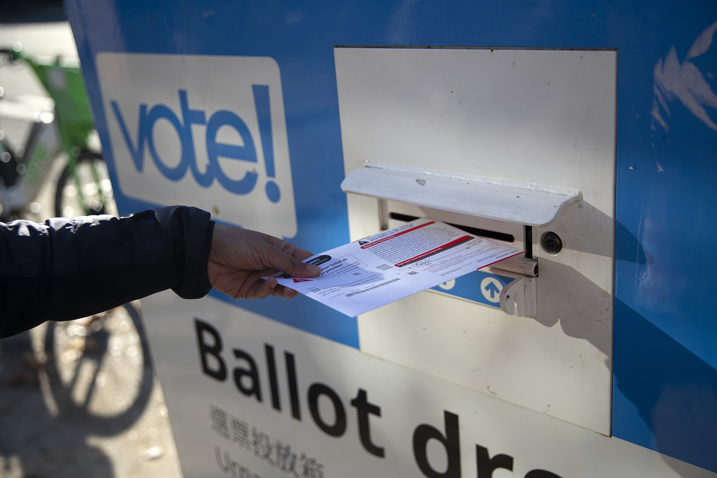 caption: A voter drops off their ballot on Monday, November 4, 2024, at the intersection of Mercer Street and First Avenue North in Seattle. 