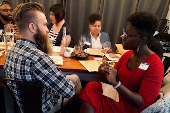 caption: Curiosity Club member Jeffrey Howard talks with KUOW producer Adwoa Gyimah-Brempong at The Cloud Room in Seattle for Queeriosity Club. Fellow Club members Timothy Bardlavens (far left), Ginger Chien (center) and Mellina White Cusack (right) chat in the background. June 6, 2019. 