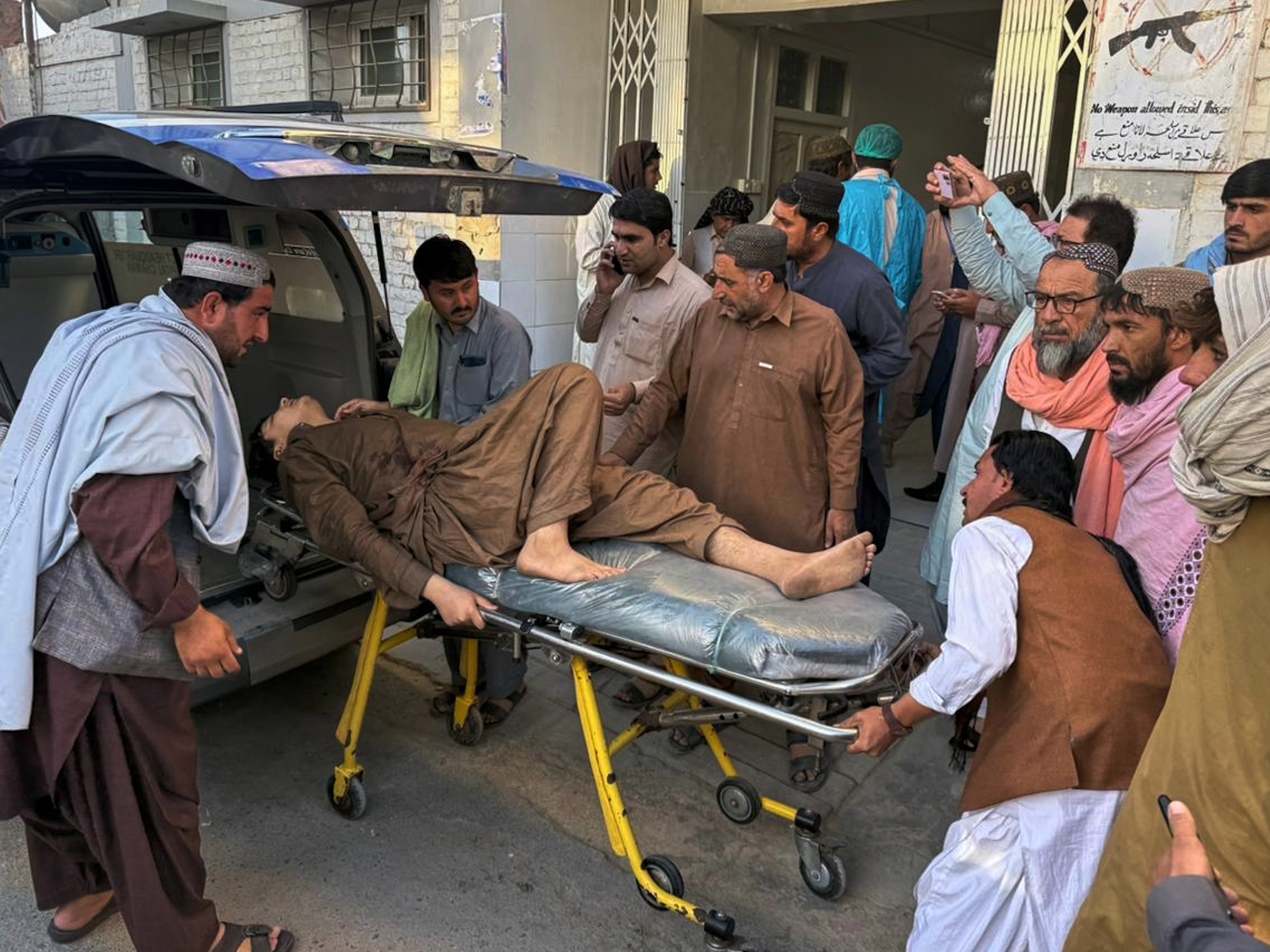caption: People bring a man who was injured in the clashes between Pakistani and Afghan forces in the border area for medical treatment at a hospital in Chaman, Pakistan, on Wednesday.