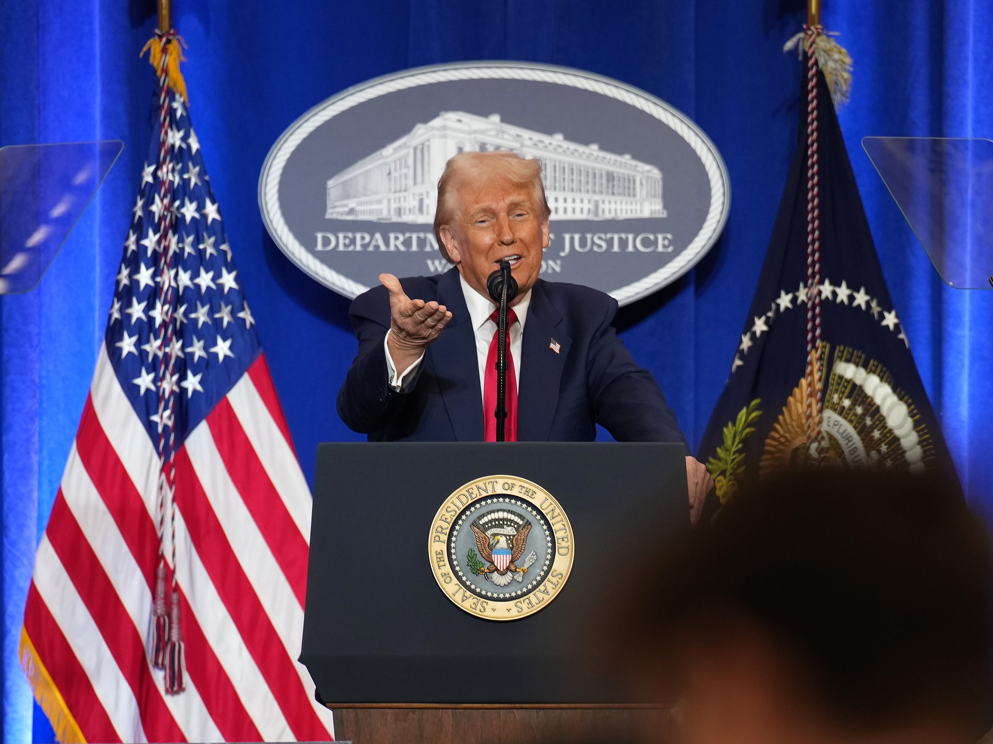 caption: President Trump speaks at the Justice Department on March 14.