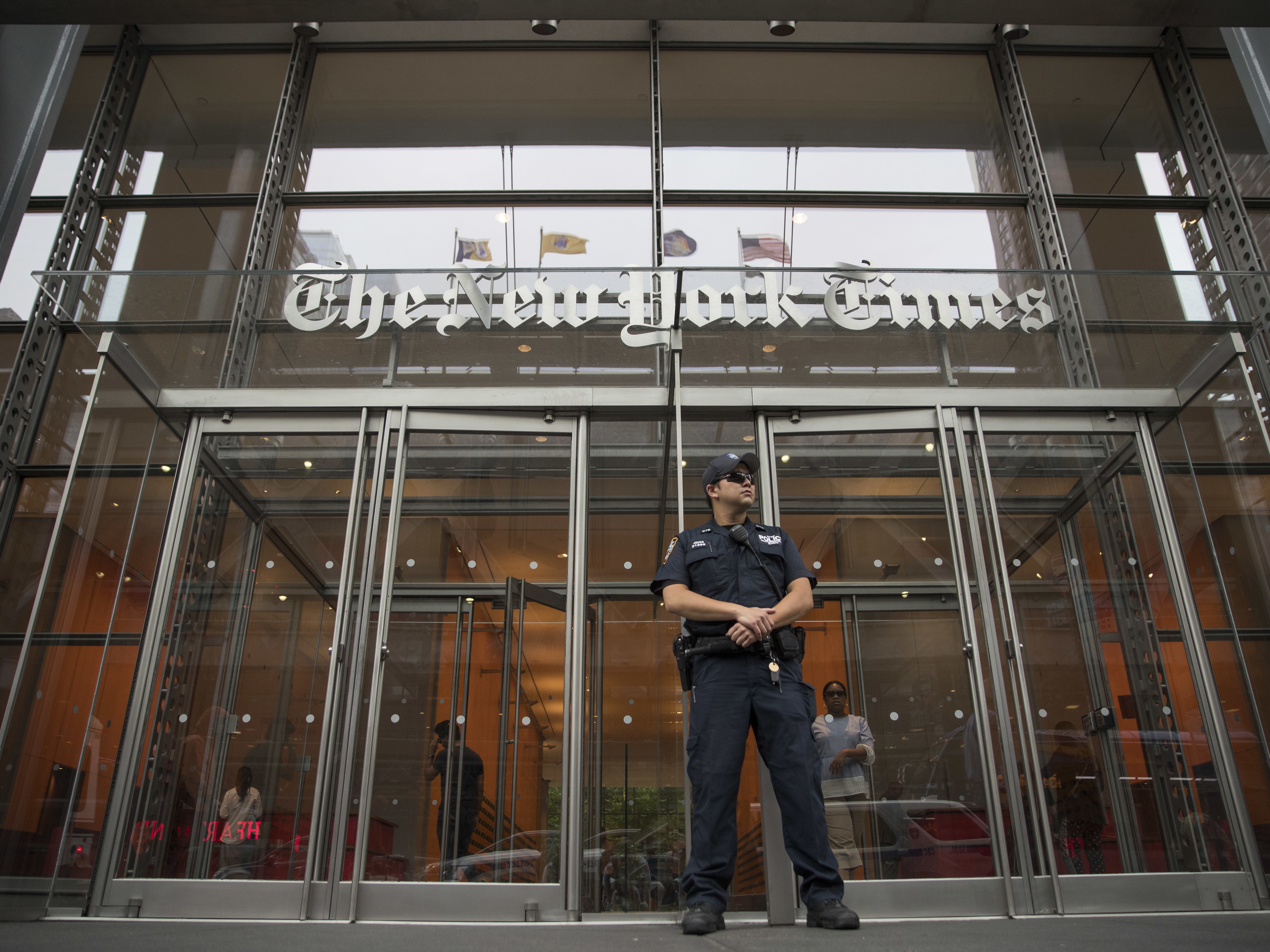 caption: A police officer stands guard outside The New York Times building in New York, on June 28, 2018.