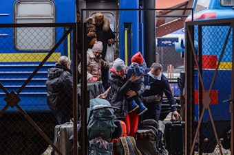 caption: Millions have fled Ukraine, with many coming to Poland through the the Przemysl main train station in Poland.