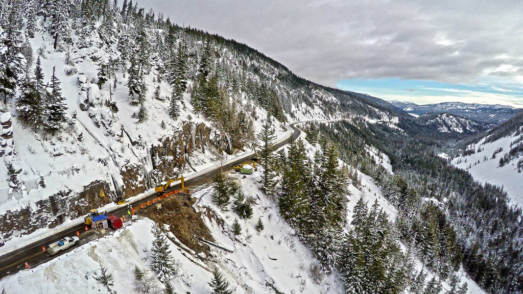 caption: Crews repair one of three roadway washouts at milepost 154 over White Pass on Dec. 16. The pass has since reopened.