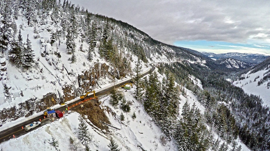 caption: Crews repair one of three roadway washouts at milepost 154 over White Pass on Dec. 16. The pass has since reopened.