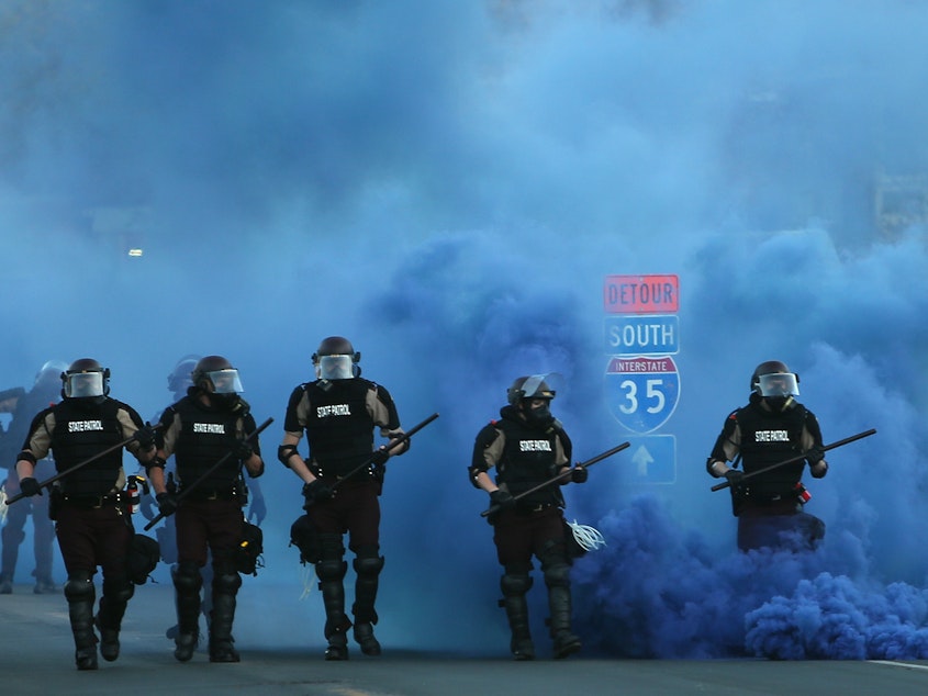 caption: Police advance on demonstrators who are protesting the killing of George Floyd on May 30, 2020 in Minneapolis, Minnesota.