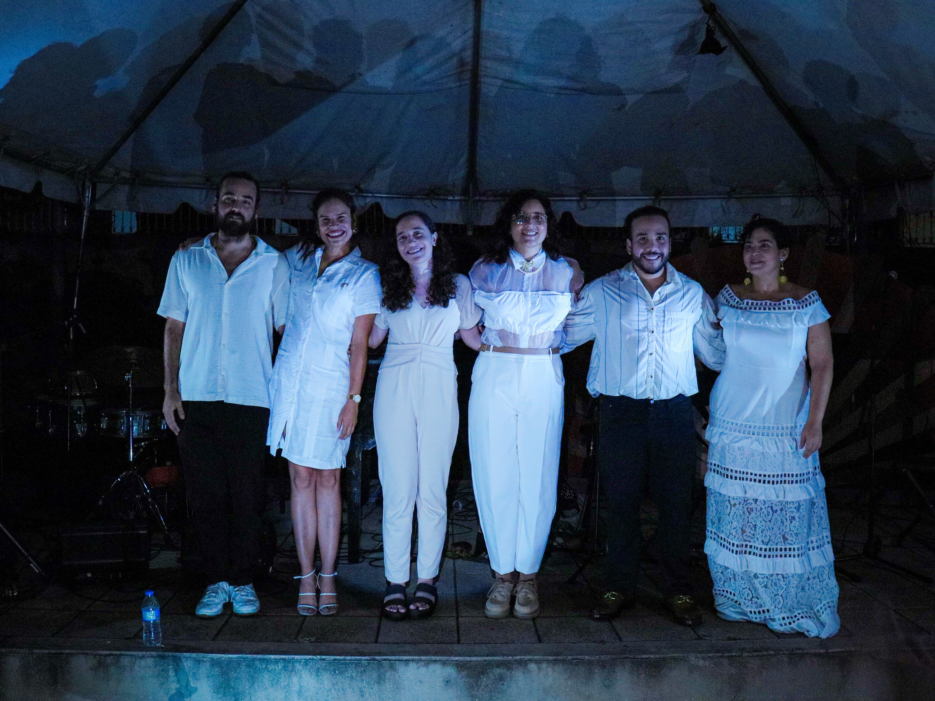 caption: Pianist Daniela Santos, second from left, with the ensemble she was performing with when one of Puerto Rico's frequent power outages interrupted the Aug. 24 concert she'd worked six years to debut. Afterward, the musicians posed for a photo illuminated by cellphones from the audience.