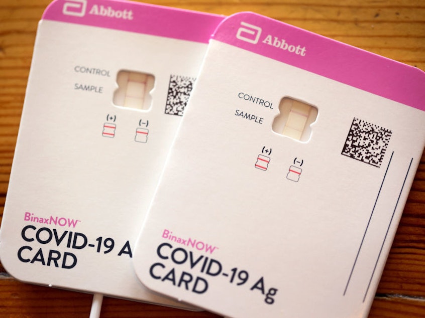 caption: At-home rapid COVID-19 tests, like this one from Abbott, can be difficult to find and cost-prohibitive for some families.