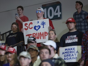 caption: Supporters of Republican presidential candidate and former President Donald Trump listen while he speaks during a Get Out The Vote rally at Coastal Carolina University on Feb. 10 in Conway, S.C.