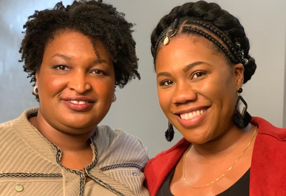 caption: Stacey Abrams, left, of Fair Fight, and Seattle journalist Jenna Hanchard.