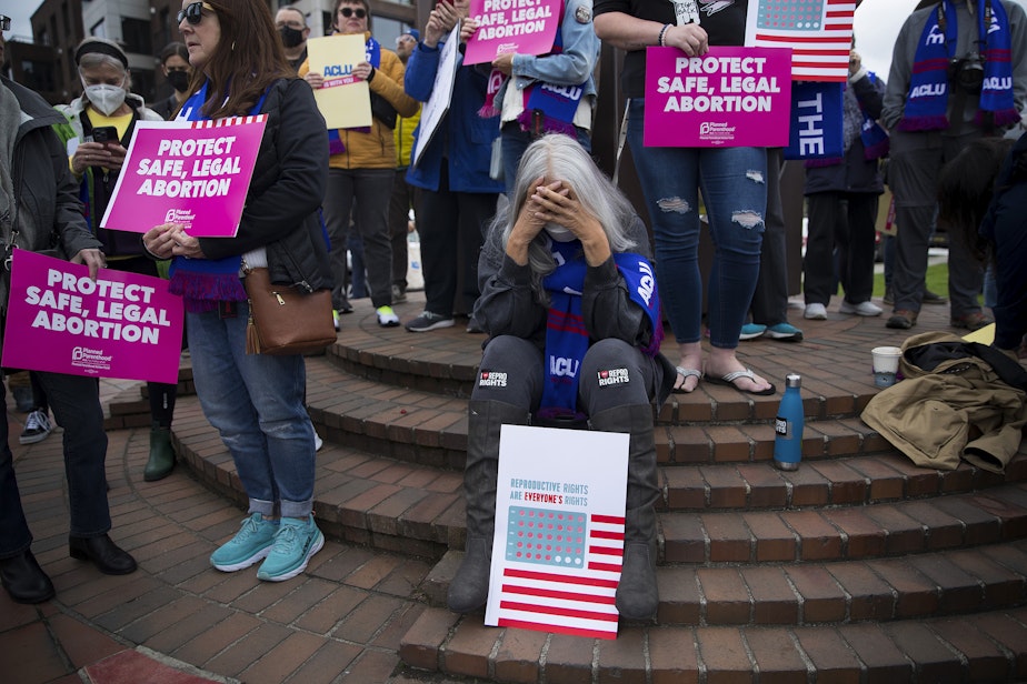 caption: Jackie Jacobs holds her head in her hands before the start of a pro-choice rally and press conference on Tuesday, May 3, 2022, at Kerry Park in Seattle. 