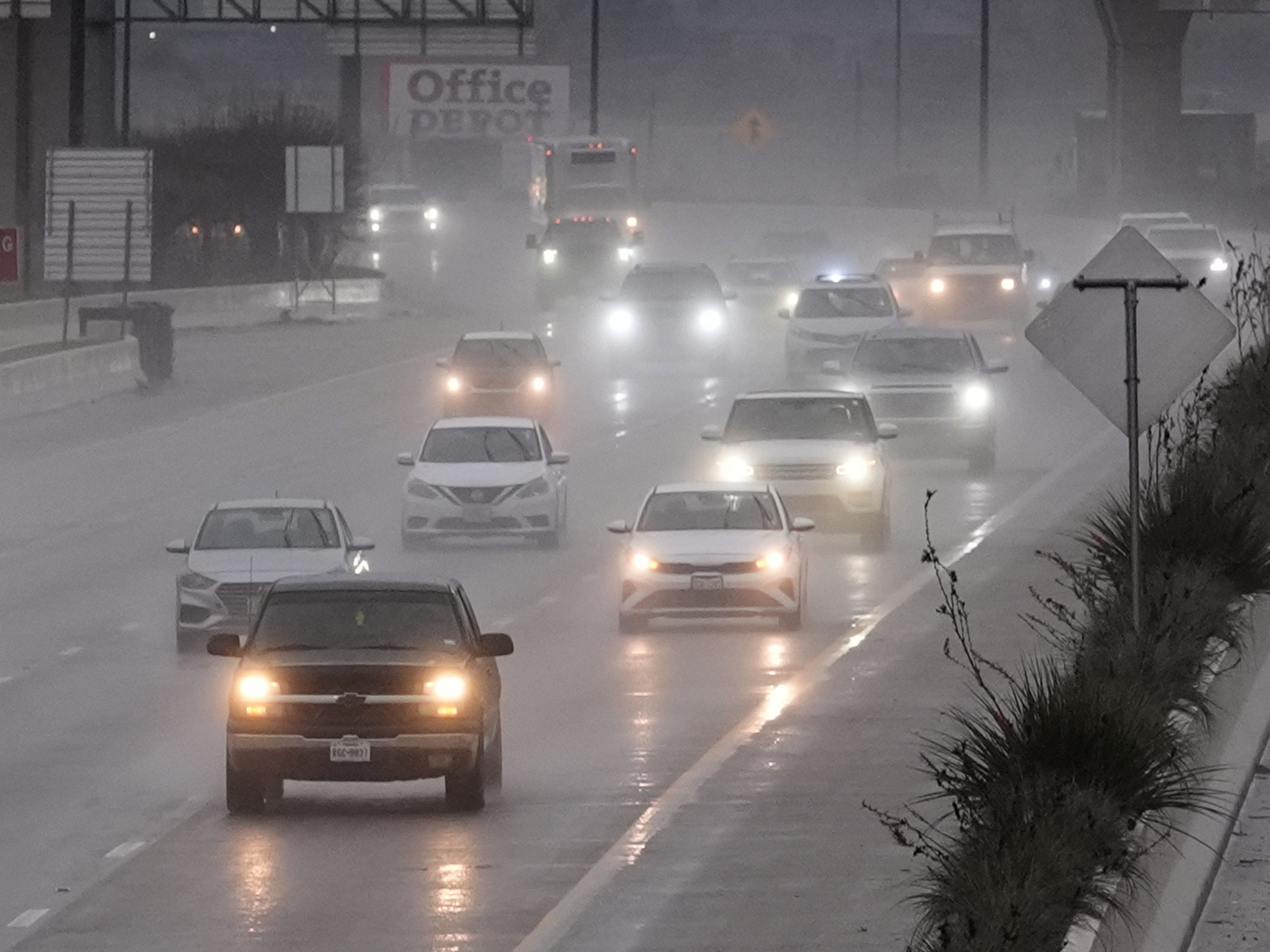 caption: Vehicles make their way on a rain soaked highway in Dallas on Thursday.