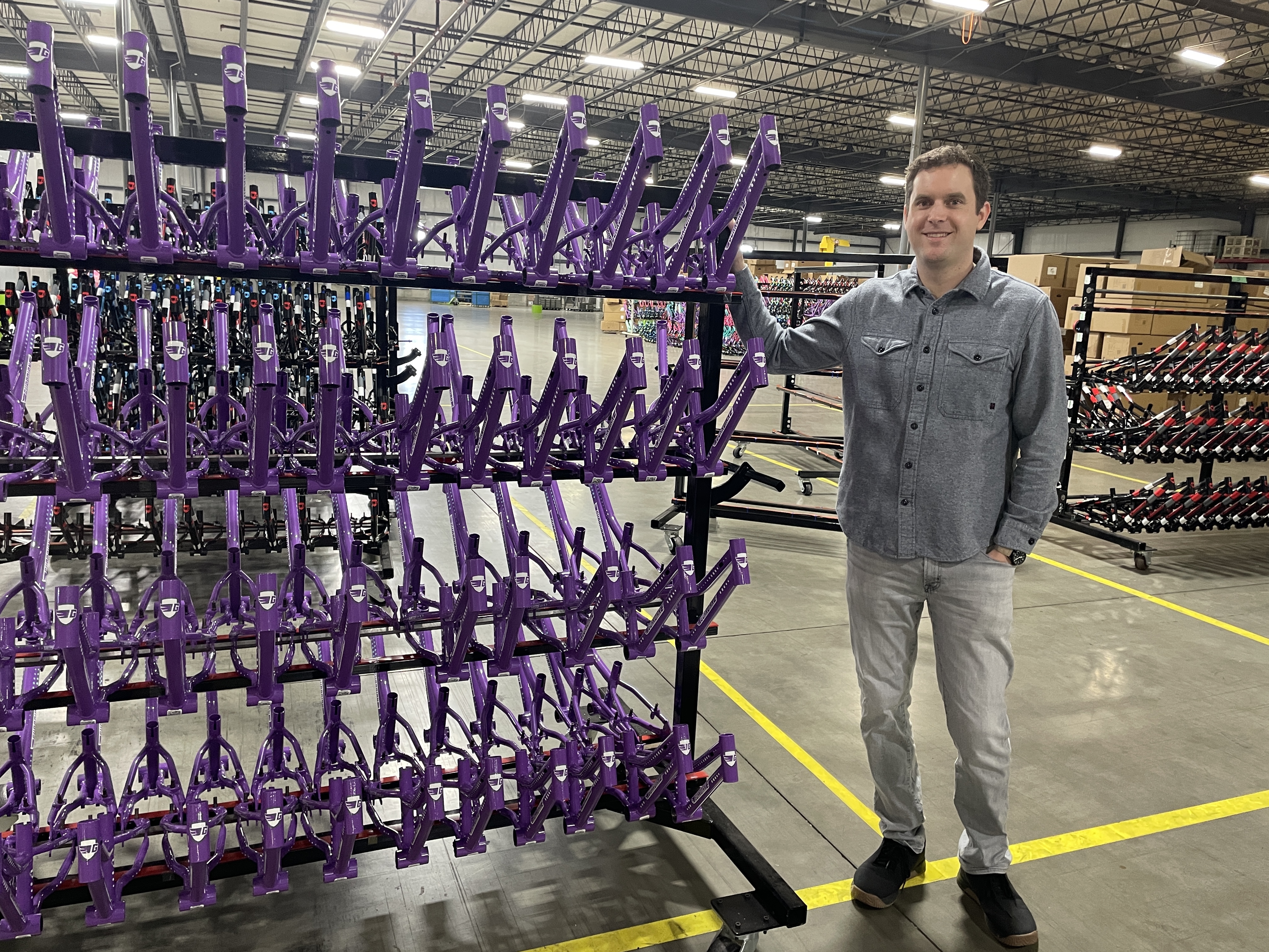 caption: Brian Riley, the CEO of the Guardian Bike Company, showcases a rack of frames that were built in his factory in Seymour, Indiana.