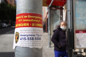 caption: A sign posted in San Francisco's Chinatown neighborhood on March 8 encourages people to call a police tip line if they witness a crime.